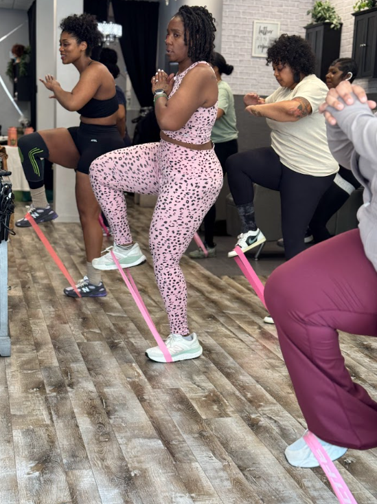 Glutes by Dom small-group class doing banded squats together